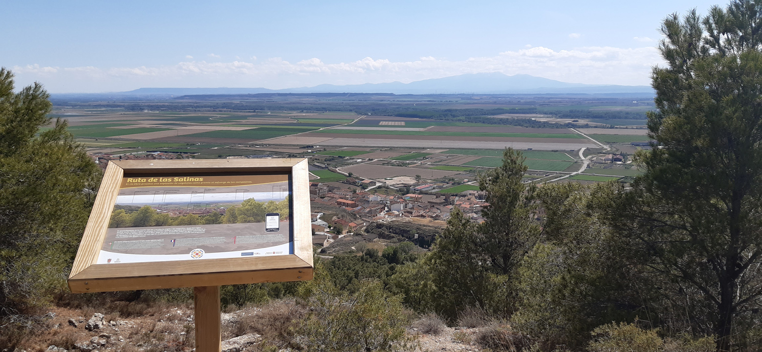 panel del sendero, detrás el pueblo y campos